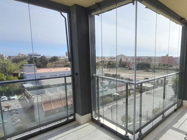 Instalación de cortinas de cristal en balcón con forma irregular.